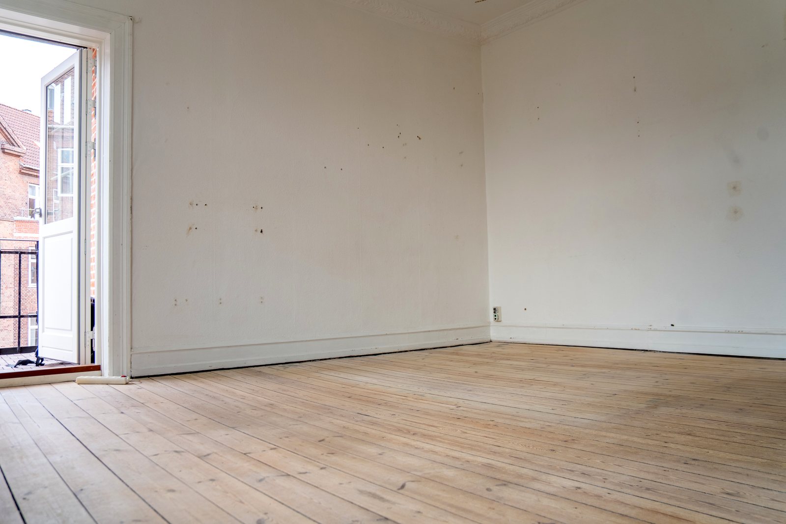 Stuen mod altanen med mærker på væggene før renovering